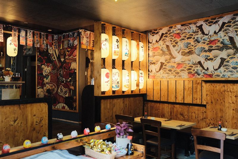Dining room with paper lanterns, wooden walls and a crane mural